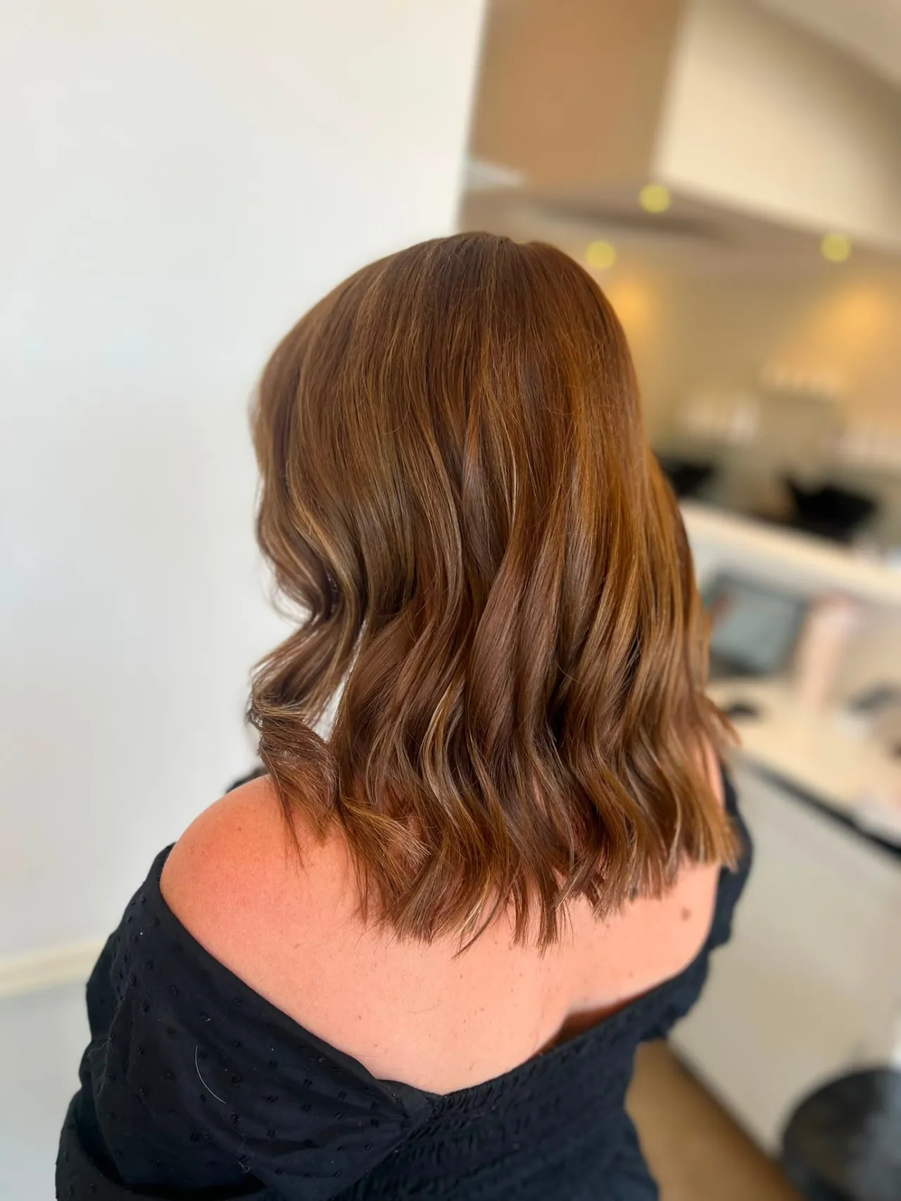 Shoulder-length reddish-brown hair with added volume from hair extensions at Esther Alexander