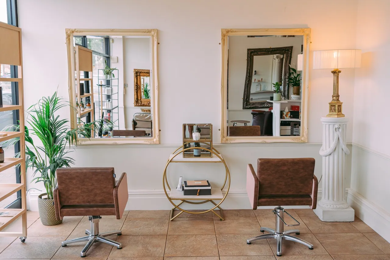 Twin styling stations with ornate cream mirrors at Esther Alexander