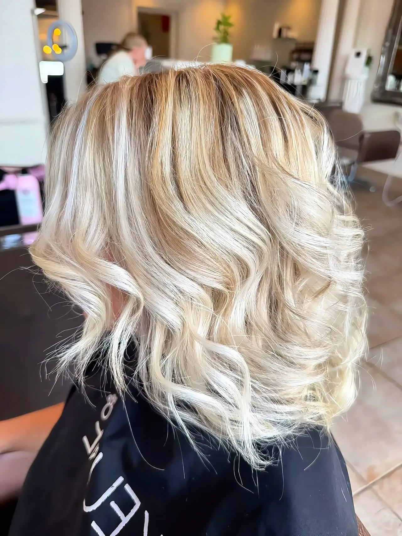Half head highlights blended through mid-length blonde waves