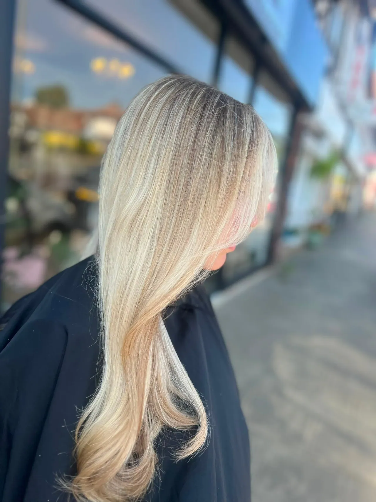 Root regrowth blended into cool blonde lengths