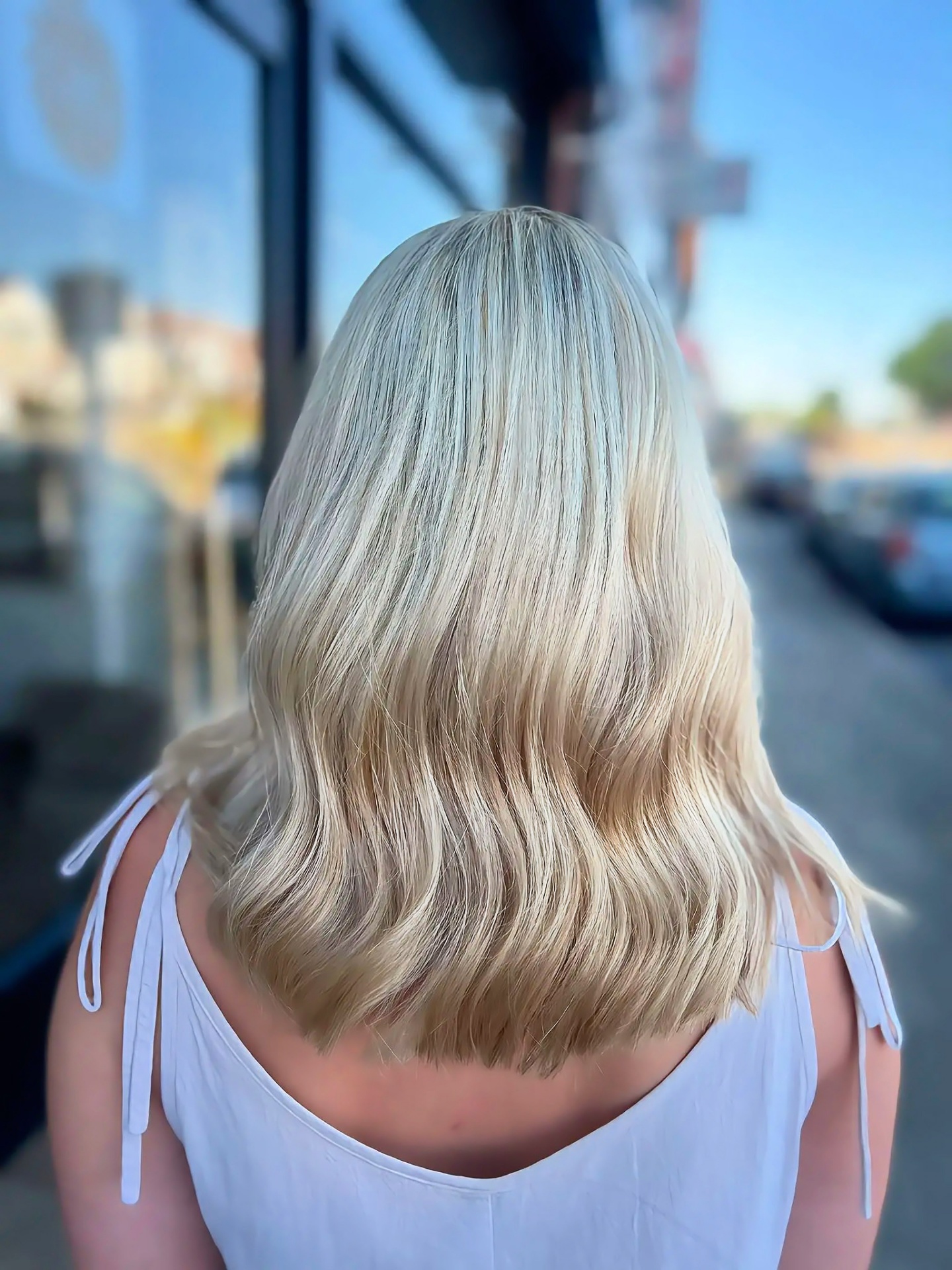 Mid-length blonde balayage with soft waves, near Epsom